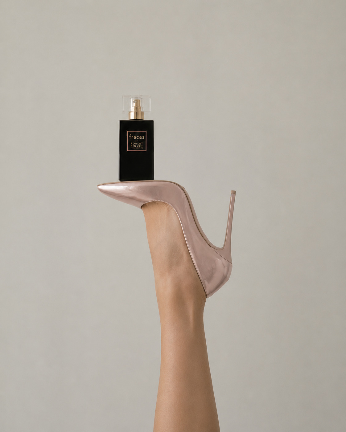 Robert Piguet Fracas perfume bottle balanced on a pale pink stiletto heel